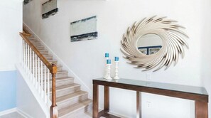 A staircase with wooden railings and a dark wooden console table with two white candle holders. - 6BR Windsor Hills Pool & Themed Rooms (Kissimmee)