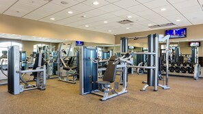 A gym with various exercise machines, mirrors, and a television screen. - Fun Family Home Mario Game Room & Star Wars (Kissimmee)