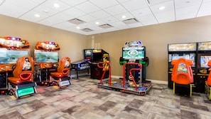 An indoor arcade with various gaming machines, including racing and fighting games. - Fun Family Home Mario Game Room & Star Wars (Kissimmee)