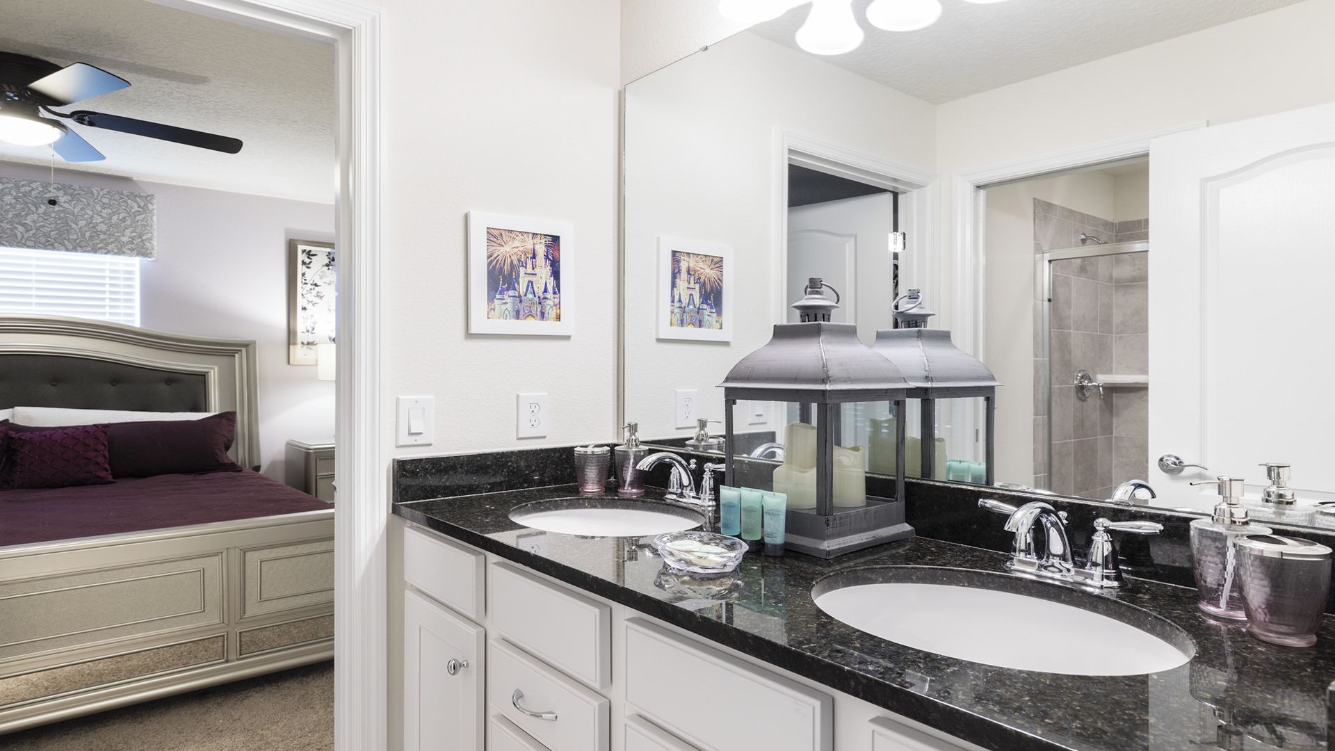 A modern bathroom with two sinks, a large mirror, and a ceiling fan.