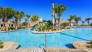 A swimming pool with a water slide, palm trees, and a lifeguard tower. - Luxe Villa With Stunning Pool & Resort Access (Davenport)