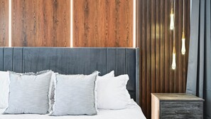 A modern bedroom with a wooden headboard, a grey upholstered headboard, and a bedside table with a drawer. - Luxe Home w/ Ps5, Pool, & Themed Rooms Near Disney (Kissimmee)
