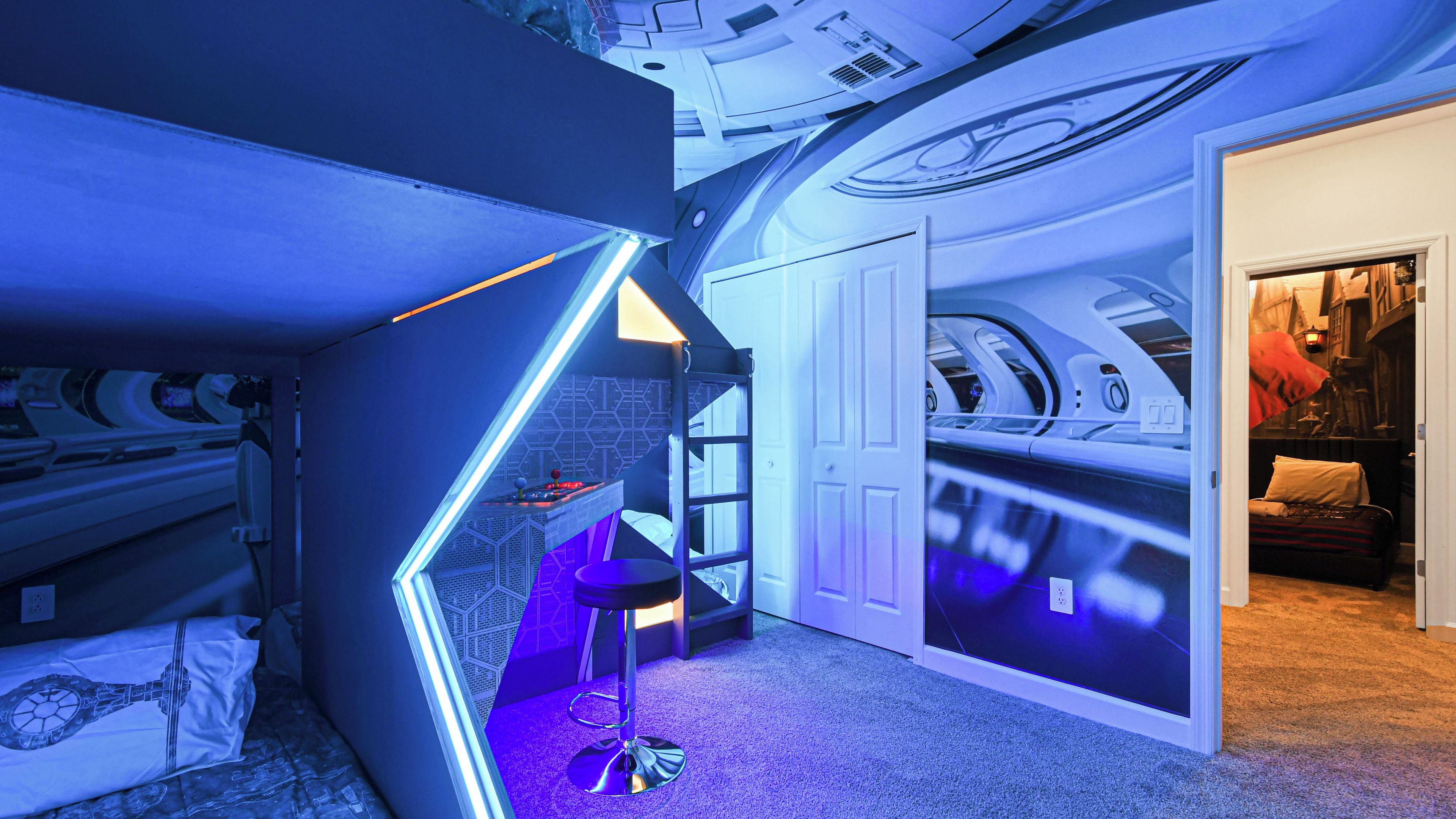 A room with bunk beds, a desk, and a ladder.