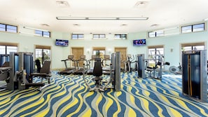 A spacious gym with various exercise equipment, large windows, and a patterned carpet. - Spacious Champions Gate Home for Family Getaways (Davenport)