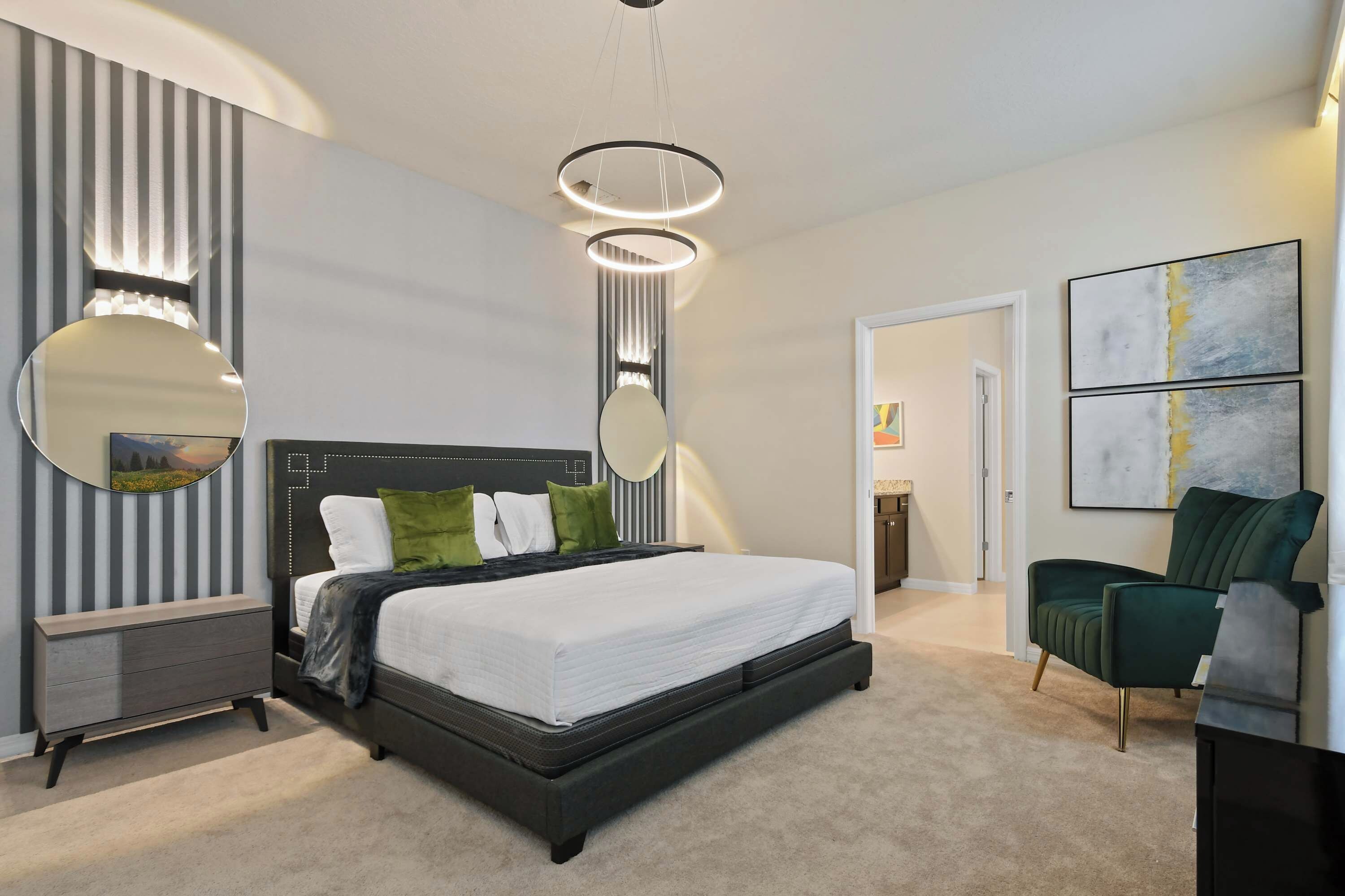 Un dormitorio moderno con una cama grande, mesitas de noche, un aparador y una silla.