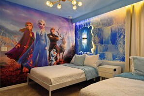 A bedroom with a mural of animated characters, a bed, a nightstand, and a window with a view of a snowy landscape. - 10br Windsor Epic Themed Villa Private Pool (Davenport)