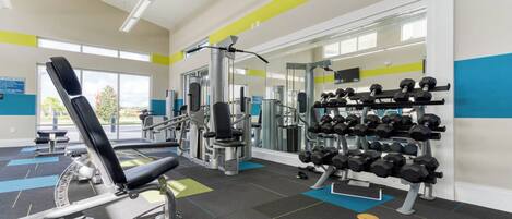 Ein Fitnessstudio mit Trainingsgeräten, einem Wand-Hantelständer und einem großen Fenster.