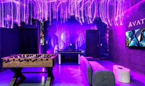 A room with a foosball table, a pool table, and a sofa. - New! Avatar Game Room & Harry Potter Fantasy World (Davenport)