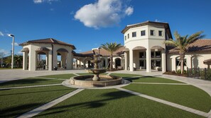 A courtyard with a fountain, palm trees, and a building with arched walkways. - Lakeview/star Wars & Minions Rooms + Resort Access (Kissimmee)