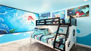 A child's bunk bed with a mermaid-themed bedspread, surrounded by ocean-themed wall art. - Lakeview/star Wars & Minions Rooms + Resort Access (Kissimmee)