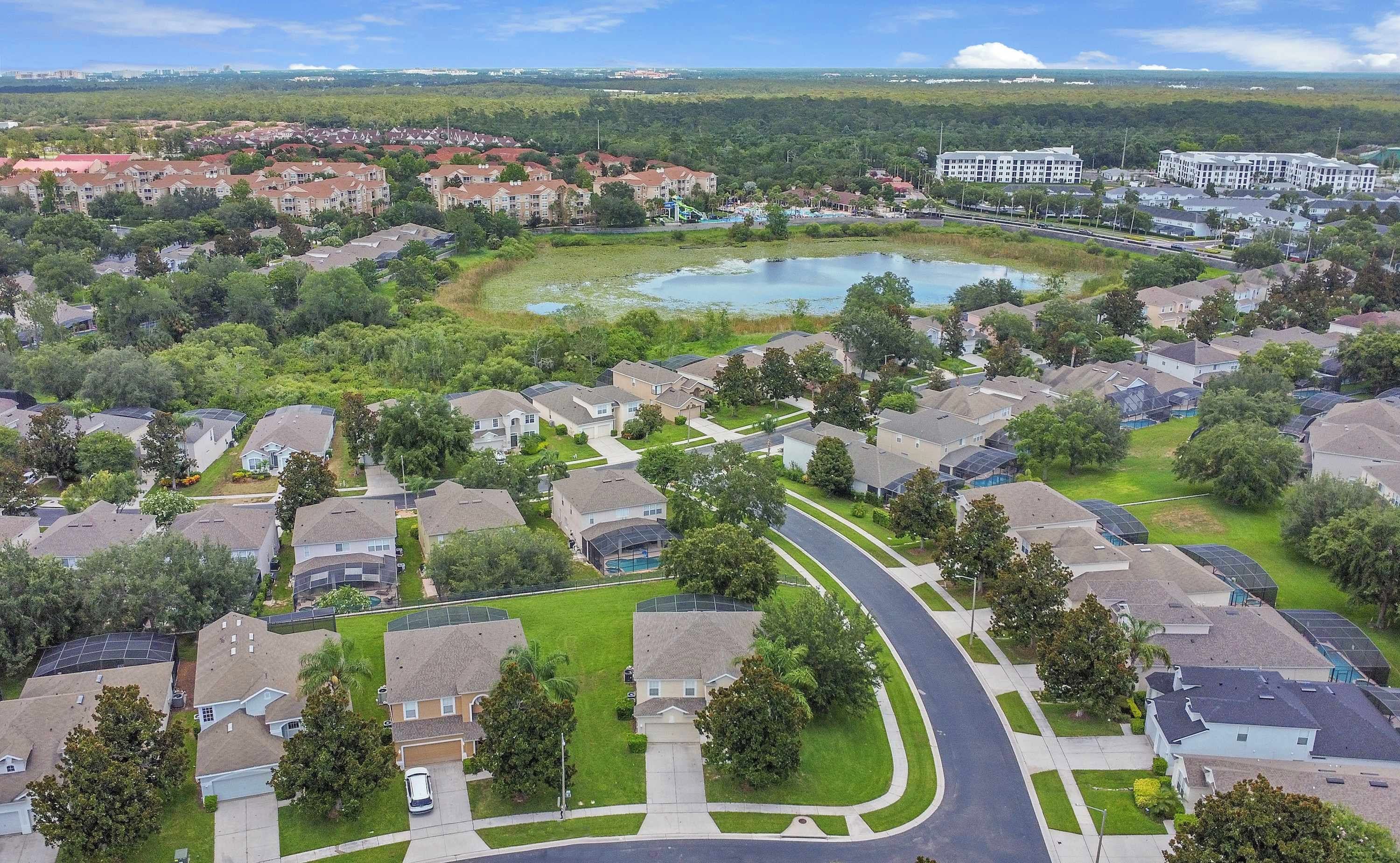 A residential area with houses, a curved road, and a large body of water.