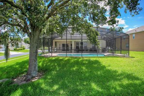 A house with a covered outdoor area, a swimming pool, and a lawn. - 6BR Disney Villa w/ Pool/spa/game in Windsor Hills (Kissimmee)