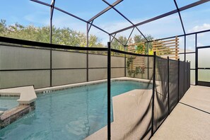 A swimming pool with a safety fence, surrounded by a clear sky and trees. - Star Wars & Jurassic Park Fun Near Disney (Kissimmee)