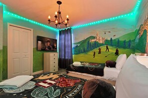 A bedroom with a bed, a dresser, a painting, and a chandelier. - Lakeview Villa Epic Game Room & Pool (Kissimmee)