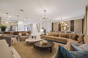 A modern living room with a sofa, coffee table, and chairs. - Lakeview Villa Epic Game Room & Pool (Kissimmee)