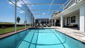 A swimming pool with a covered area, lounge chairs, and a view of the sky. - Enchanting Moana & Hogwarts Rooms Close to Parks (Davenport)