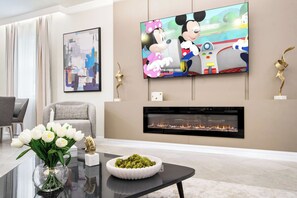 Ein modernes Wohnzimmer mit Flachbildfernseher, Kamin und dekorativen Accessoires.