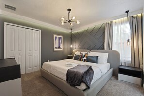 A modern bedroom with a bed, bedside tables, a wardrobe, and a ceiling light fixture. - Lakeview Home w/ Mario Game Room & Themed Bedrooms (Kissimmee)