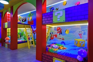 A children's playroom with colorful murals, bunk beds, and various toys. - Lakeview Home w/ Mario Game Room & Themed Bedrooms (Kissimmee)