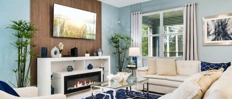 A living room with a fireplace, sofa, and television.