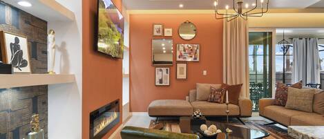 A modern living room with a fireplace, sofas, a coffee table, and a TV mounted on the wall.