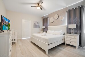 A bedroom with a bed, nightstands, a TV, and a ceiling fan. - 9br/star Wars/harrypotter Themed Rooms/pool/disney (Davenport)