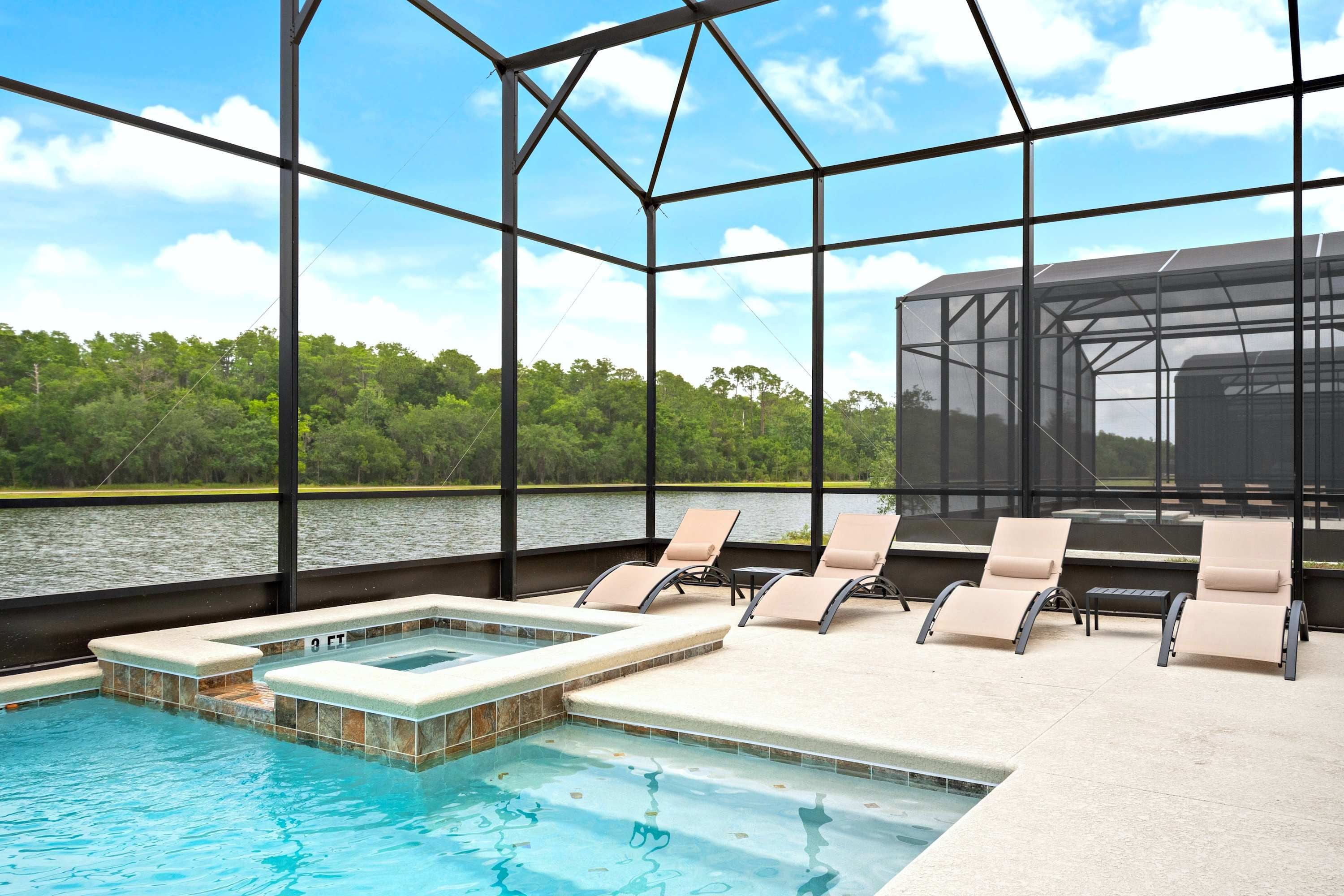 Un espace piscine avec vue sur un lac, entouré d’une structure en métal.