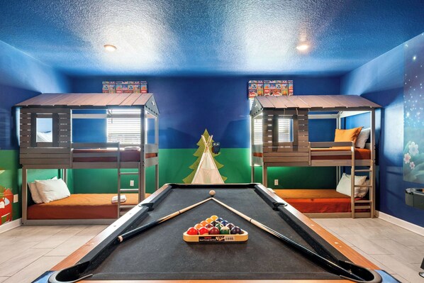 A pool table with a set of pool balls, two bunk beds, and a green wall with a Christmas tree decoration. - Games/themed Rooms/greenview/ 9BR @ Storeylake! (Kissimmee)