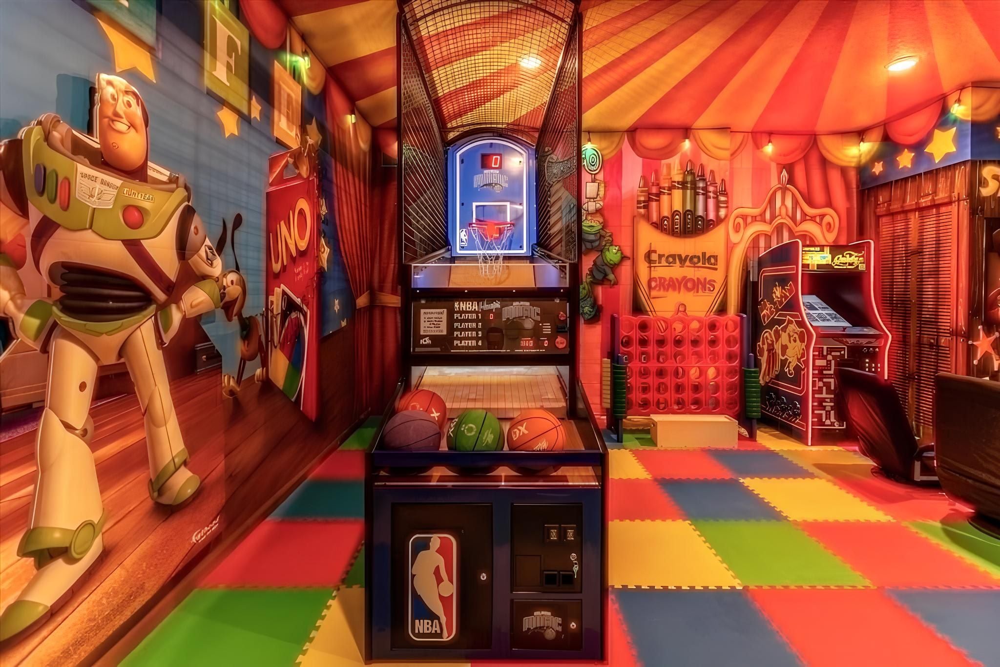 Une salle d’arcade aux couleurs vives, avec un panier de basket, une machine à pinces et une exposition de ballons de basket.