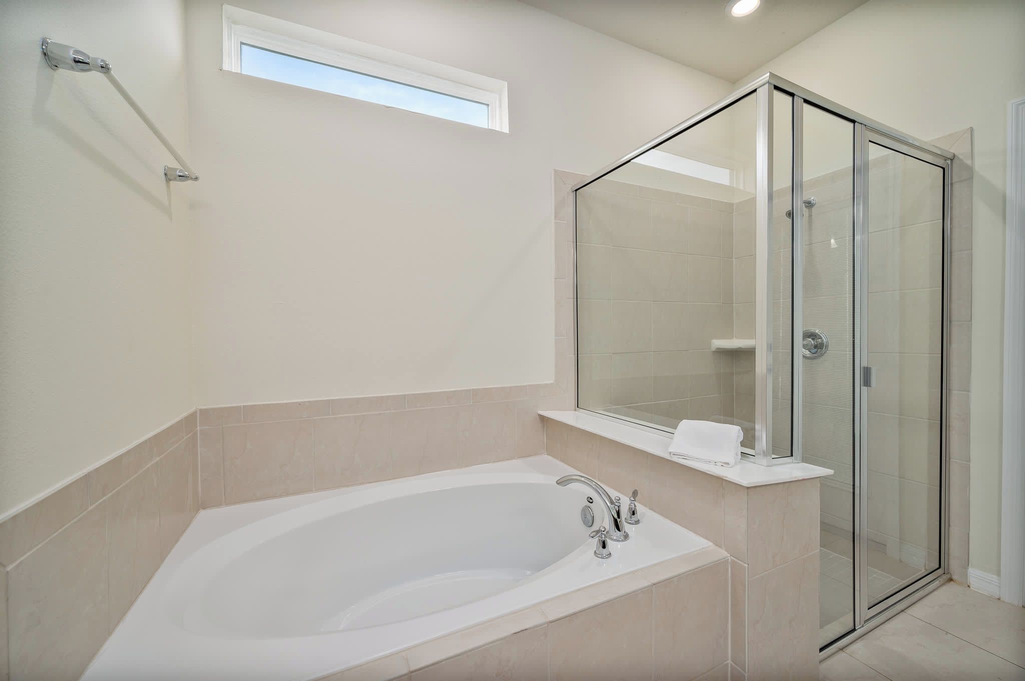 Een moderne badkamer met een vrijstaand bad, een glazen douchecabine en een grote spiegel.