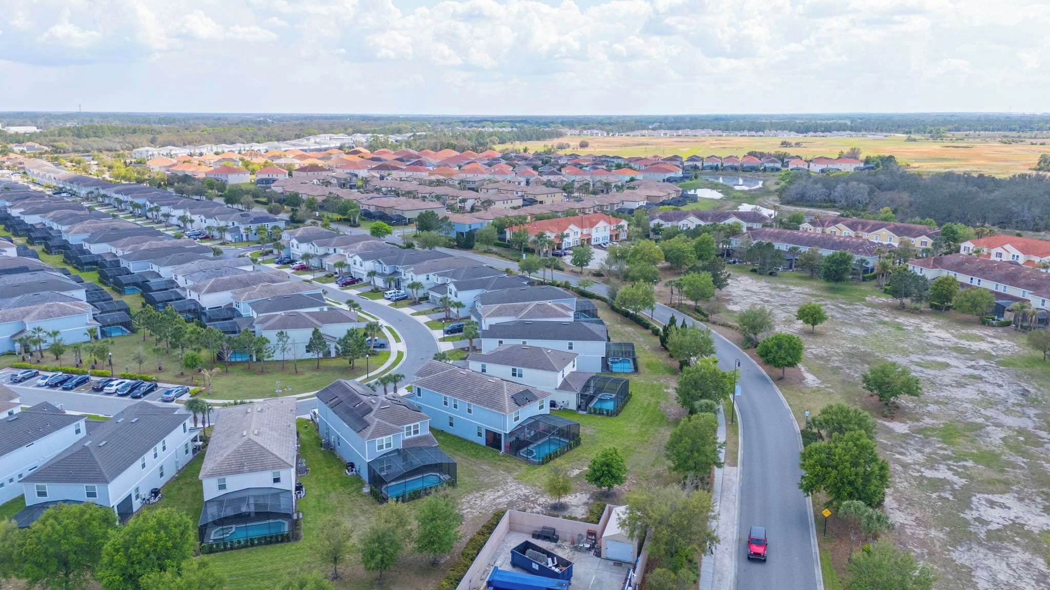 A residential area with houses, a road, and a clear sky.
