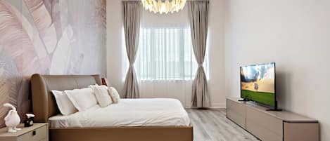 Un dormitorio moderno con una cama grande, un televisor en un mueble bajo y una pared decorativa.