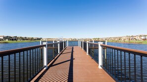 Un muelle de madera que conduce a una masa de agua bajo un cielo despejado.