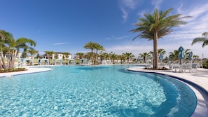 A large, clear swimming pool surrounded by palm trees and lounge chairs. - Extraordinary Solara 7BR Private Pool/spa Near Disney (Kissimmee)