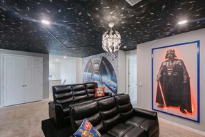 A room with a starry ceiling, a Darth Vader poster, and a Star Wars-themed couch. - Solara 9BR Lakeview Estate With Private Spa & Themed Suites (Kissimmee)