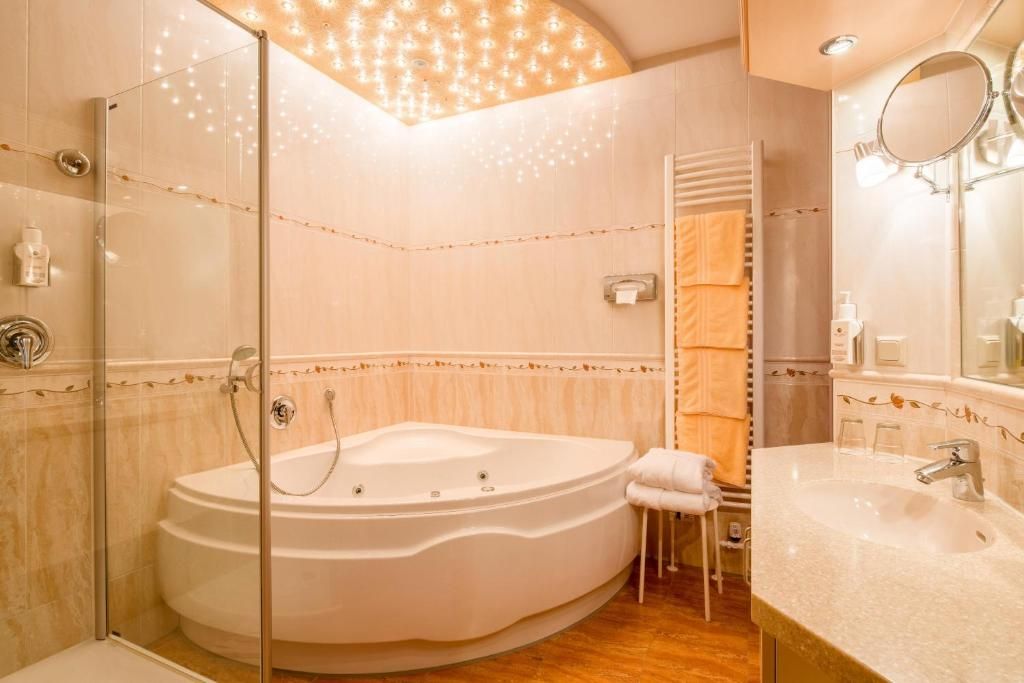 A modern bathroom with a freestanding bathtub, a glass-enclosed shower, and a vanity with a sink and mirror.