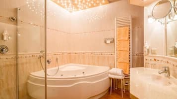 A modern bathroom with a freestanding bathtub, a glass-enclosed shower, and a vanity with a sink and mirror.