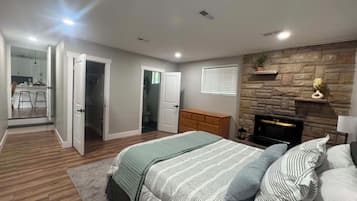 Un dormitorio con cama, chimenea y pared de piedra.