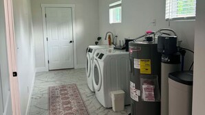 A laundry room with a washing machine, dryer, and a water heater. - Welcome to Rosehill (Dayton)