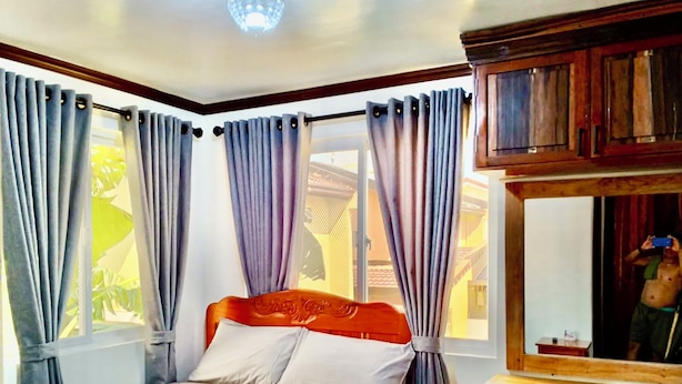 A bedroom with a bed, curtains, a desk, and a mirror. - Noah Bed&Breakfast 3Private Room NEWHOME Quiet Place to Stay 14mins PPS Airport (Puerto Princesa City)