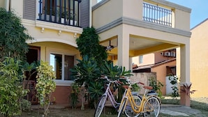A two-story residential building with a balcony and a bicycle parked in front. - Noah Bed&Breakfast 3Private Room NEWHOME Quiet Place to Stay 14mins PPS Airport (Puerto Princesa City)