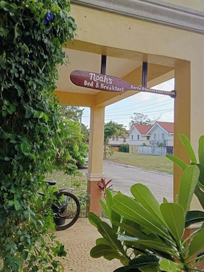 Señal de Noah's Bed & Breakfast con vistas a una zona residencial y una bicicleta estacionada.