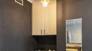 Una cocina moderna con encimera de granito, un lavamanos, una estufa y una lámpara colgante.
