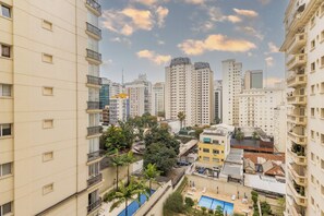 A high-rise residential building with multiple balconies and a swimming pool area. - Matiz Manhattan Hotel - Gym Pool & Sauna (São Paulo)