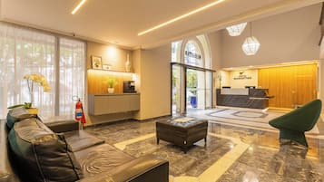 Un hall d’hôtel comprenant un comptoir d’accueil, un espace salon et un extincteur.