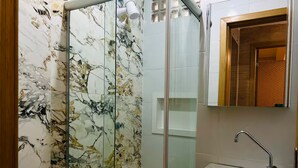 A bathroom with a toilet, a glass shower enclosure, and a sink with a mirror above it. - 402 Functional and Welcoming. (Belém)