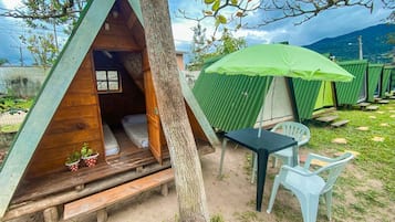 A treehouse with a wooden interior, a small table, and a green umbrella.