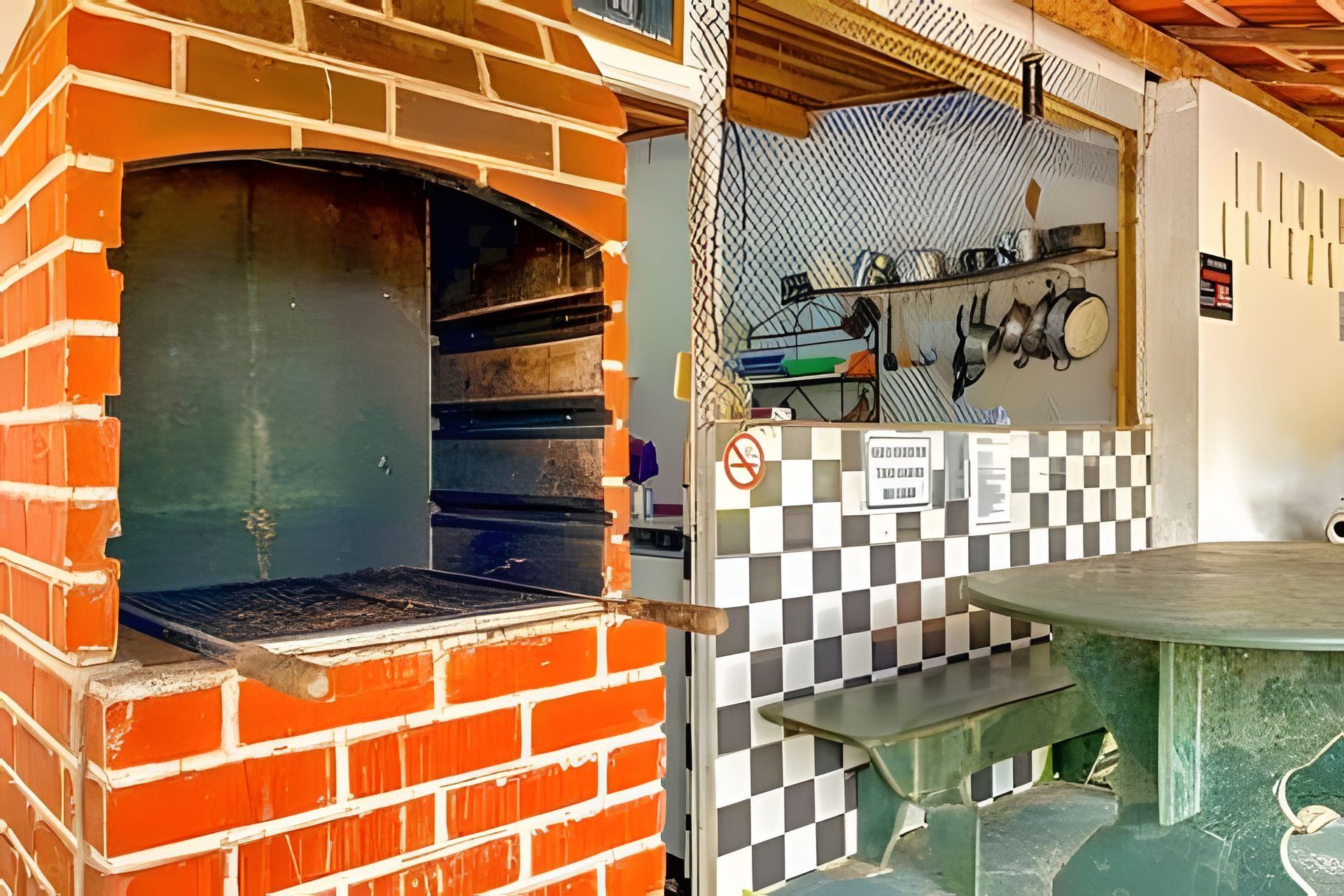 Ein Backofen mit Schachbrettmuster-Spritzschutz und einem Metalltisch.