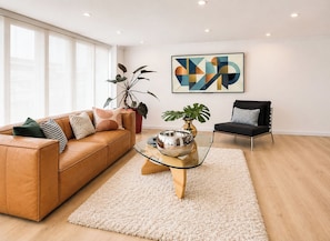 A modern living room with a leather sofa, a glass coffee table, and a black armchair. - Apartamento Premium con terraza, a pasos de la Zona t/Parque 93/area 120 mts (Bogotá, D.C.)