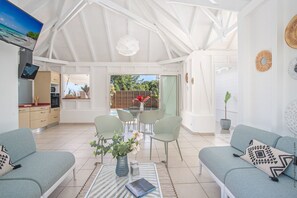 Um interior moderno com área de jantar, cozinha e espaço para sentar.